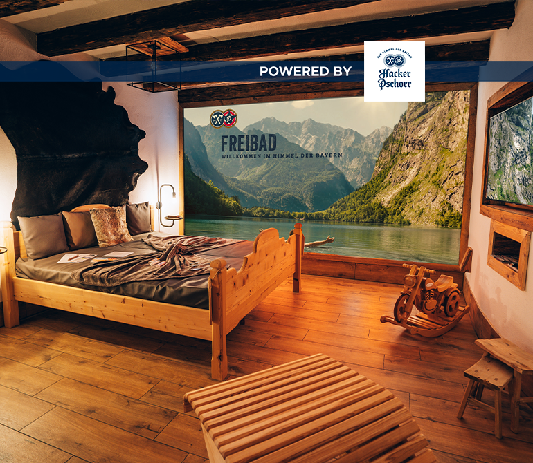 Ein Zimmer in urigem Berghütten-Feeling. In der Mitte befindet sich ein großes Bett.