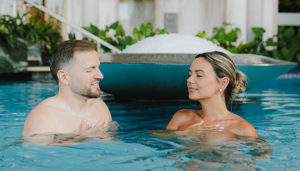Ein Pärchen entspannt im Pool und atmet tief durch.