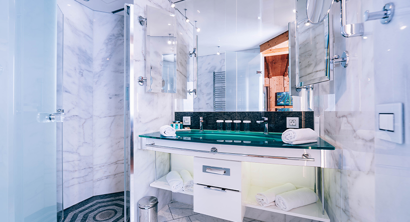 Hotel Victory Therme Erding Kapitäns Kabine Modernes Badezimmer im Hotel Victory der Therme Erding mit Glaswaschtisch, Marmordetails und großer Spiegelwand