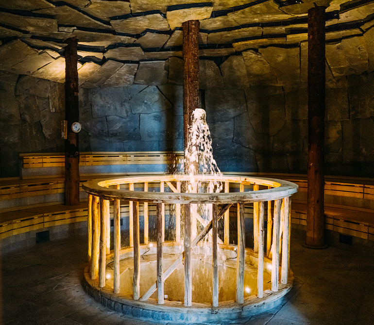 In the center of the round geyser cave with stone walls is a bubbling fountain 