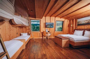 Familienfreundliche Kapitäns Kabine im Hotel Victory der Therme Erding mit maritimem Holzdesign, Doppelbett, Einzelbetten in Bootform und Ausblick auf die Therme