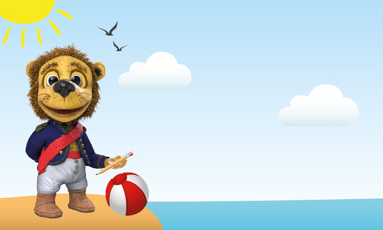 Nelson the lion with a red ball on the beach in the sunshine, seagulls and the sea in the background.
