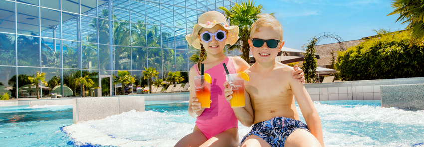 Two children are in Crazy River drinking a children's cocktail.