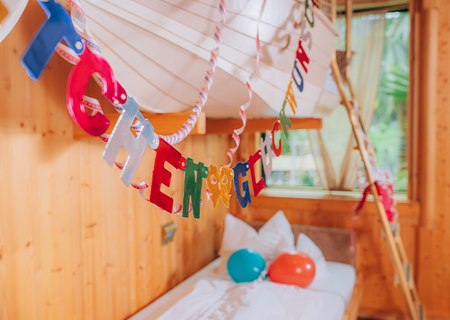 Decorative garlands with the words “Congratulations” and colorful balloons are scattered throughout the hotel rooms