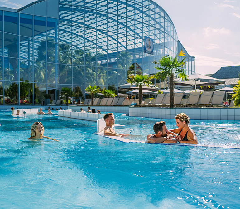 People relax in the lazy river in the outdoor area of Therme Erding.