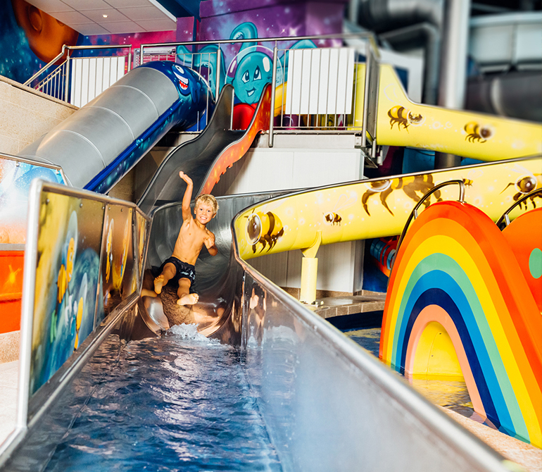 Kind rutscht auf der bunten Sunny, Moon und Star Slide.