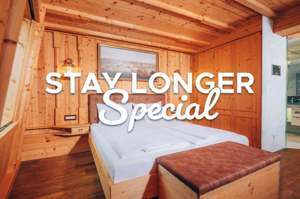 Text in the picture: Stay longer special. In the background, the cosy Admirals cabin.