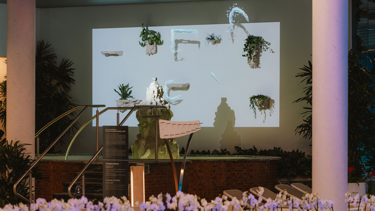Animierte Wasserstrahlen gleiten spielerisch zwischen skulpturalen Elementen und Pflanzen hinter dem Jungbrunnen hin und her.