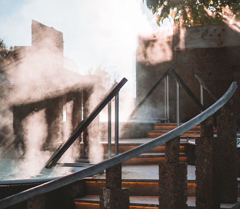 Drei runde Pools. Jeweils in der Gestalt einer halben Kokosnuss. Von den Pools steigt Wasserdampf auf.