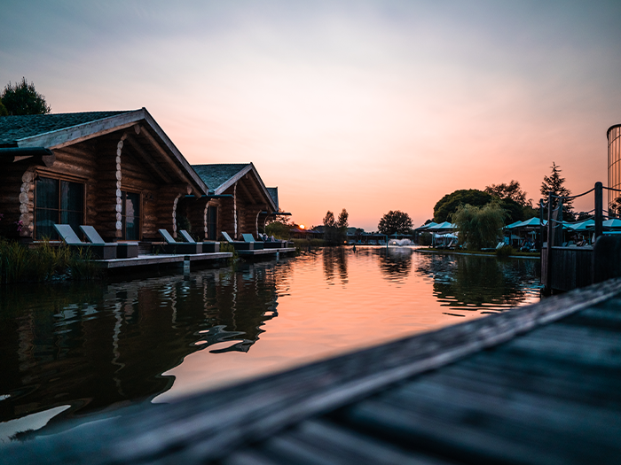 Drei See-Chalets direkt am Natursee bei Abendstimmung.