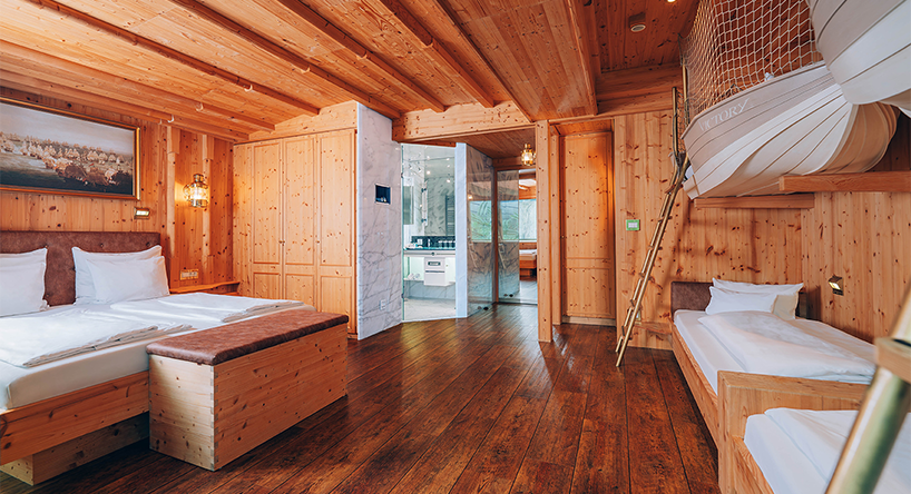 Hotel Victory Therme Erding Kapitäns Kabine Zimmer: Kapitänskabine im Hotel Victory Therme Erding. Ausstattung: Doppelbett, vier Doppelstock-Kinderbetten im Stil von Booten, Ansicht von der Fensterseite