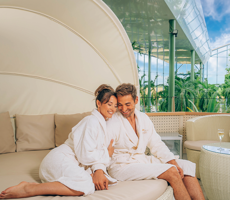 A woman hugs her sweetheart. They're enjoying a wonderful getaway in their suite.